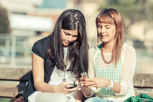 Dos mujeres jóvenes con teléfono móvil — Foto de Stock