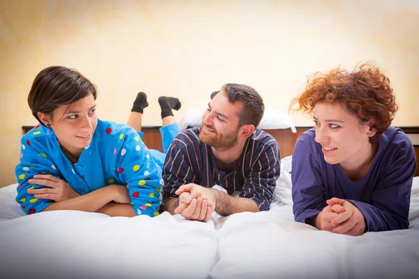 Hombre con dos mujeres en la cama —  Fotos de Stock