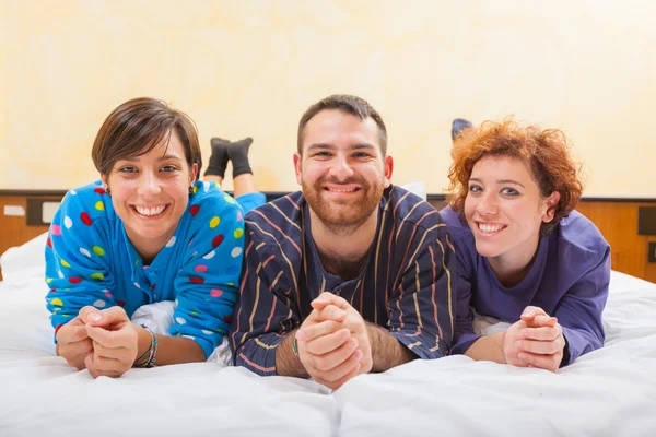 Homme avec deux femmes sur le lit — Photo