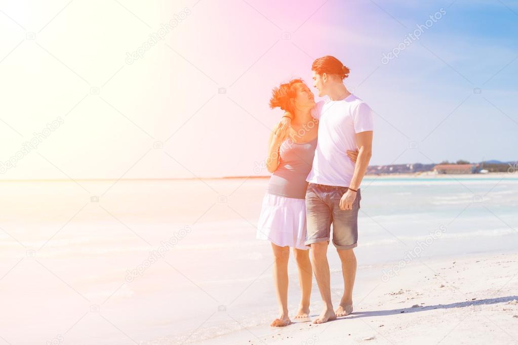 Young couple walking on caribbean beach