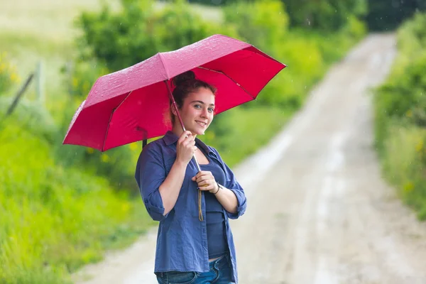 Teenage girl with red umbrella — Stockfoto