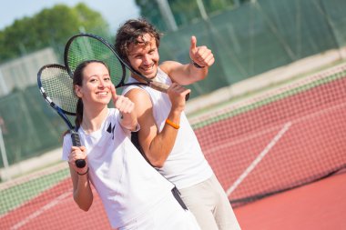 Two happy tennis players with thumbs up clipart