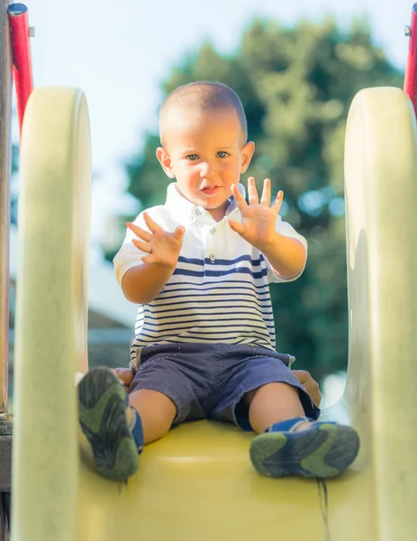 Niño jugando en el tobogán en el parque —  Fotos de Stock