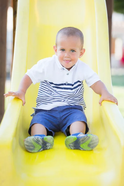 Kleiner Junge spielt auf der Rutsche im Park — Stockfoto