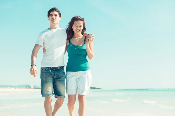 Casal jovem caminhando em uma praia caribenha — Fotografia de Stock