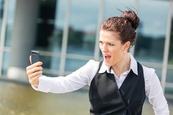 Jonge zakenvrouw schreeuwen op mobiele telefoon — Stockfoto