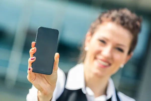 Молодая предпринимательница демонстрирует мобильный телефон — стоковое фото