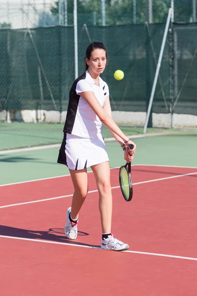 Mladá žena hraje tenis — Stock fotografie