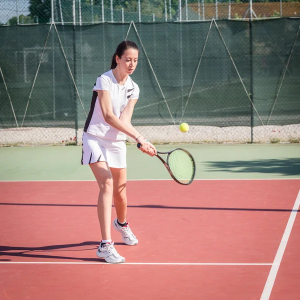 Νεαρή γυναίκα που παίζει τένις — Φωτογραφία Αρχείου