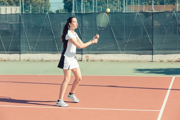 Mladá žena hraje tenis — Stock fotografie