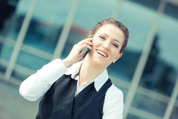 Jonge zakenvrouw in gesprek op mobiele telefoon — Stockfoto