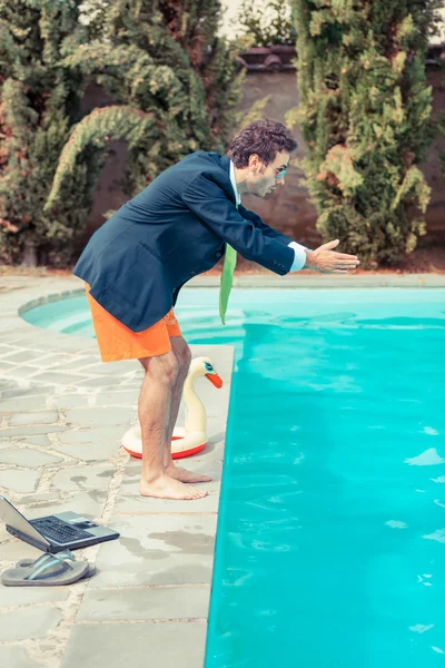 Legrační mladý podnikatel s swimmingtrunks potápění do lejno — Stock fotografie