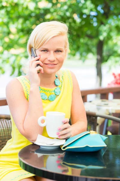 Młoda kobieta rozmowy na telefon komórkowy w kawiarni — Zdjęcie stockowe