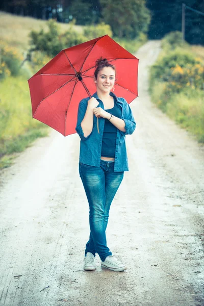 Teenager Mädchen mit rotem Regenschirm — Stockfoto