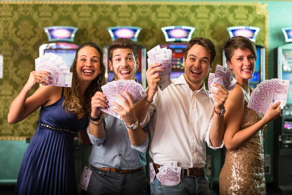 Przyjaciele wygrywając wiele pieniędzy w kasynie — Zdjęcie stockowe