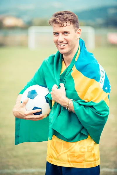 Giocatore di calcio brasiliano con palla e bandiera — Foto Stock