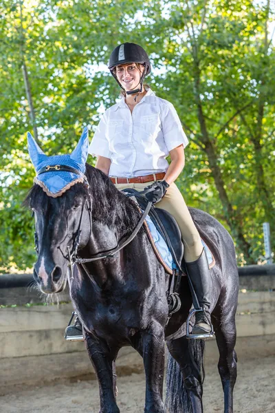 Giovane donna con un cavallo nero — Foto Stock