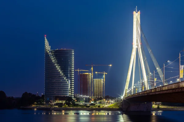 Puente moderno y edificios en Riga por la noche — Foto de Stock