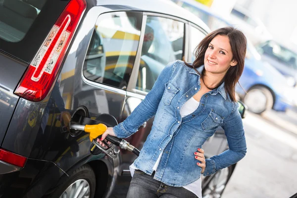 Mladá žena, plní její auto u čerpací stanice — Stock fotografie