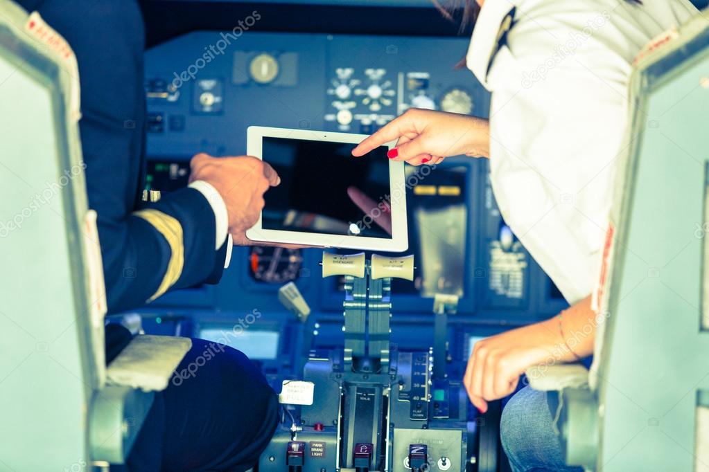 Pilot and Copilot Checking Flight Information on Digital Tablet