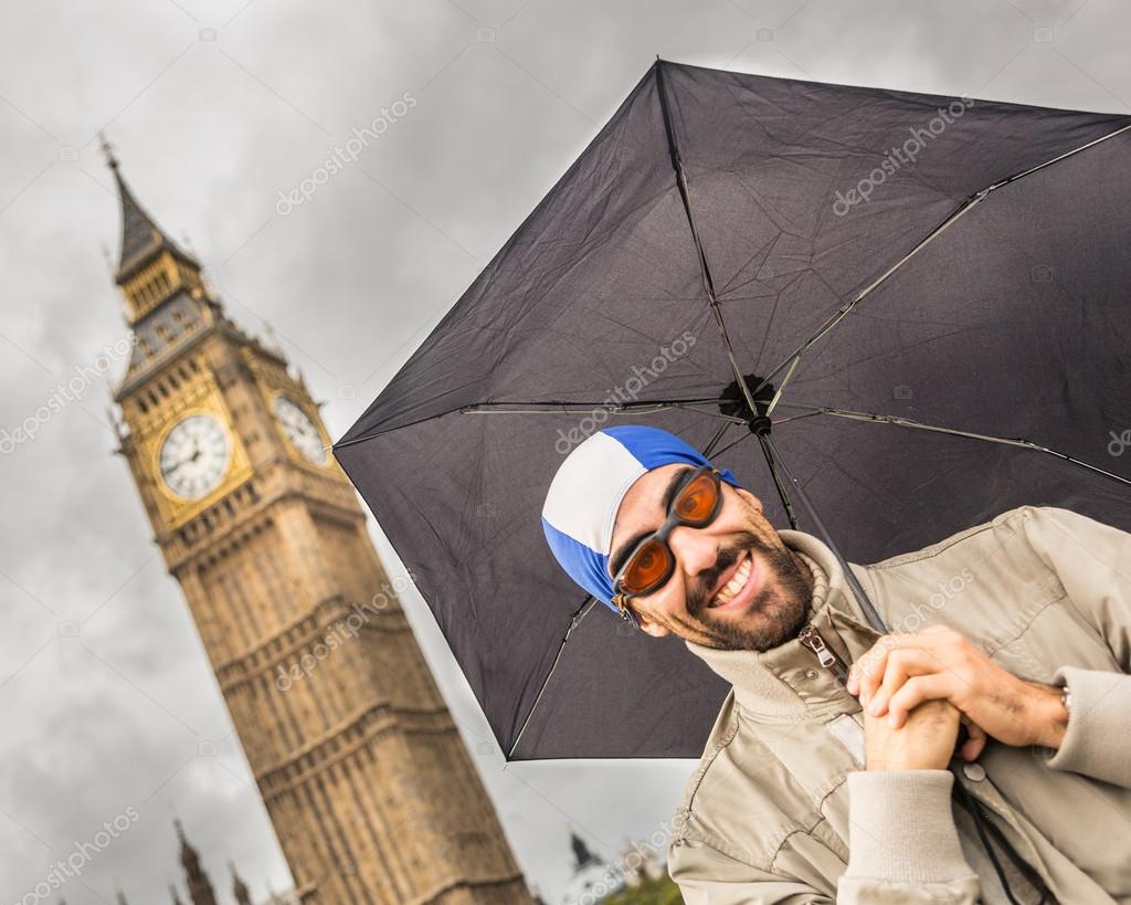 Man with Swim Cap, Goggles and Umbrella in London Stock Photo by