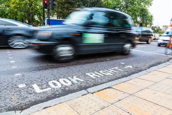 Ser rätt tecken och suddiga trafik i london — Stockfoto