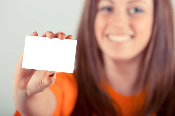 Joven mujer sosteniendo tarjeta en blanco — Foto de Stock