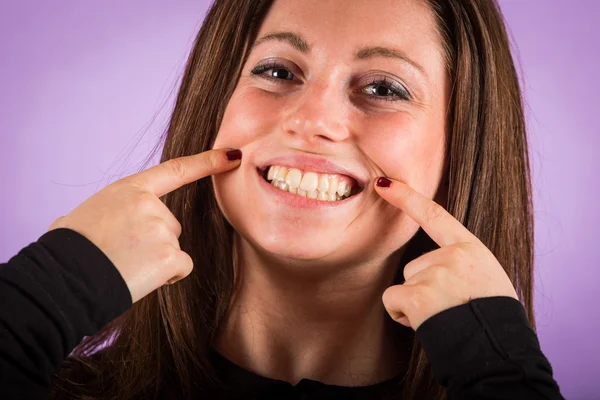 Lachende jonge vrouw op violette achtergrond — Stockfoto