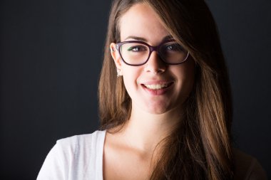 koyu arka plan üzerinde dalgın genç kadın