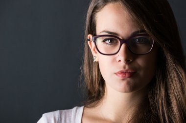 koyu arka plan üzerinde dalgın genç kadın