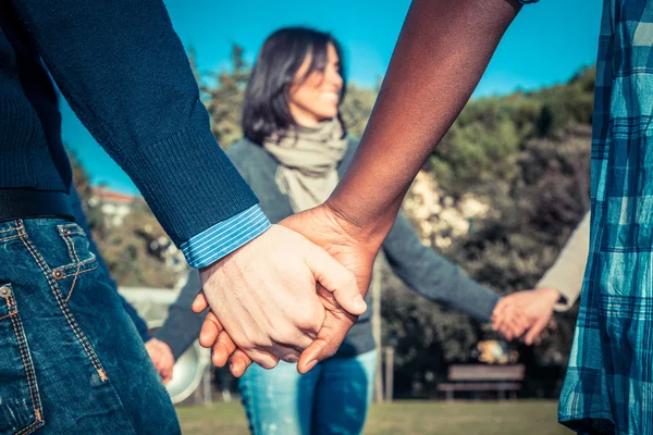 Jovens multirraciais segurando as mãos em um círculo — Fotografia de Stock