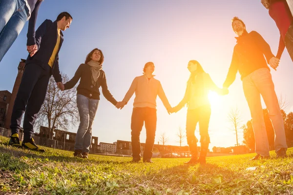 Giovani multirazziali che tengono le mani in un cerchio — Foto Stock