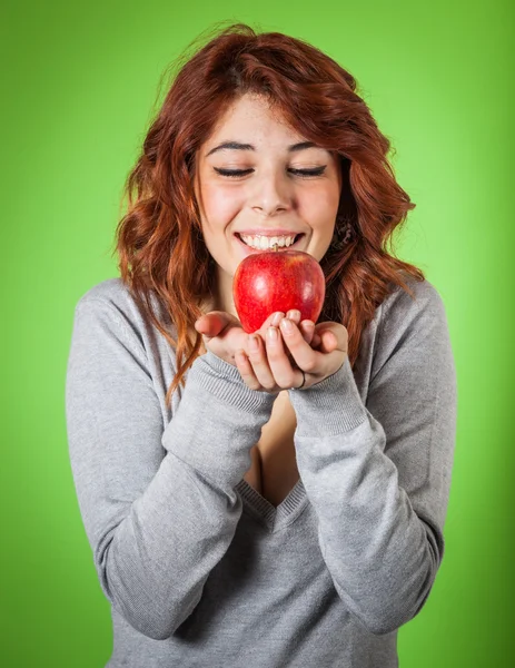 十几岁的女孩在绿色背景上举行一个红苹果 — 图库照片