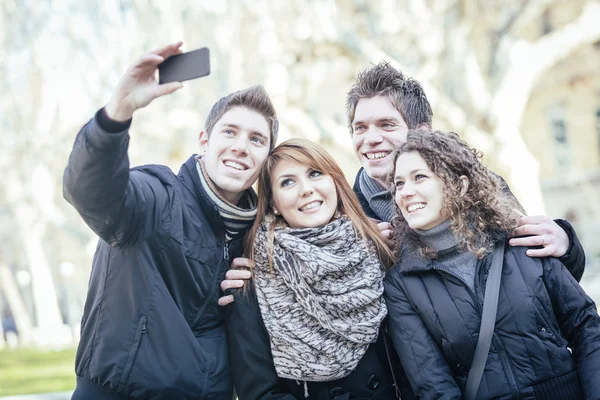 Grupo de amigos tomando auto-retratos com telefone móvel — Fotografia de Stock