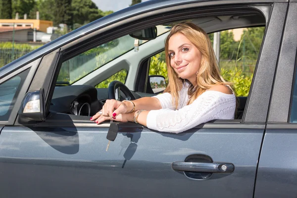 Mujer joven feliz mostrando la llave del coche — Foto de Stock