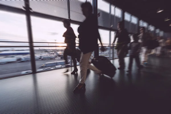 Расплывчатые пассажиры прогулки в терминале аэропорта — стоковое фото