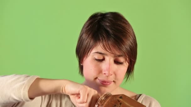 Joven mujer lamiendo dedo con crema de chocolate — Vídeos de Stock