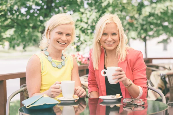 Twee mooie vrouwen drinken koffie in bar — Stockfoto