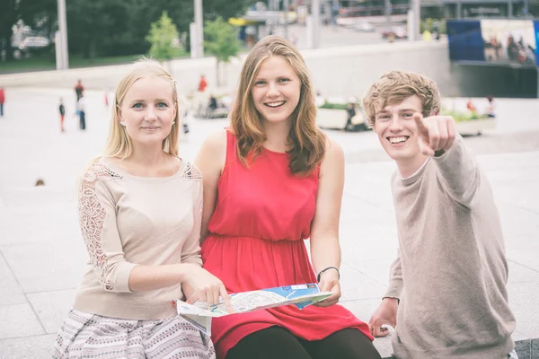 Groep vrienden op zoek op kaart — Stockfoto