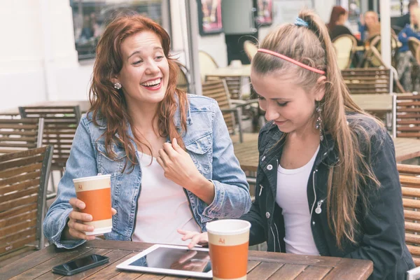 Meninas usando tablet digital no café — Fotografia de Stock