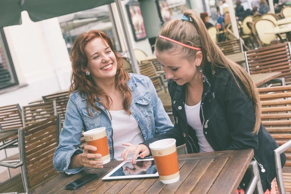 Meninas usando tablet digital no café — Fotografia de Stock