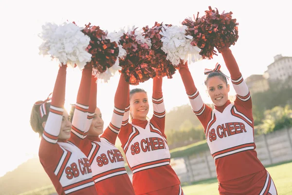 Gruppo di cheerleader con pompom rialzato — Foto Stock