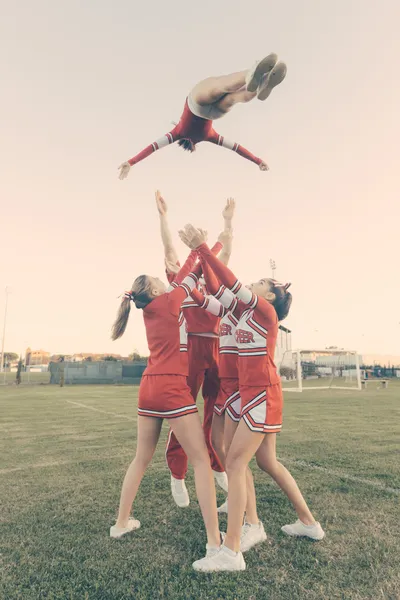 Grupo de líderes de torcida realizando acrobacias — Fotografia de Stock