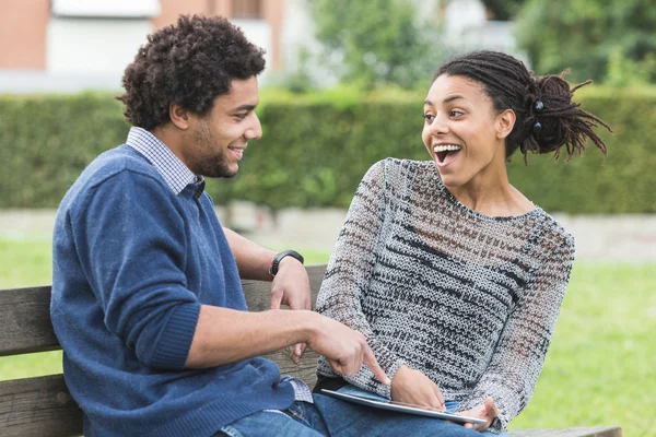 Casal de raça mista usando tablet digital — Fotografia de Stock