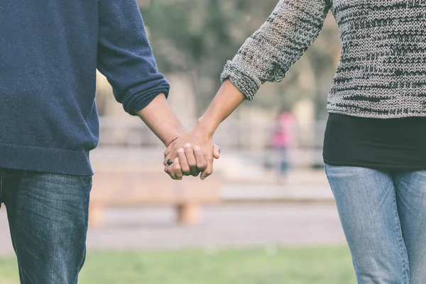 Gemischtes Paar hält Händchen — Stockfoto