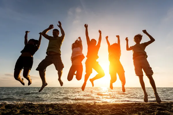 Persone che saltano in spiaggia — Foto Stock