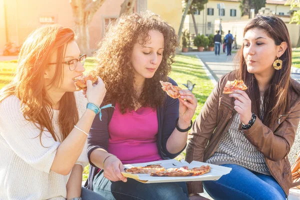 Dívky jíst pizzu ve městě — Stock fotografie