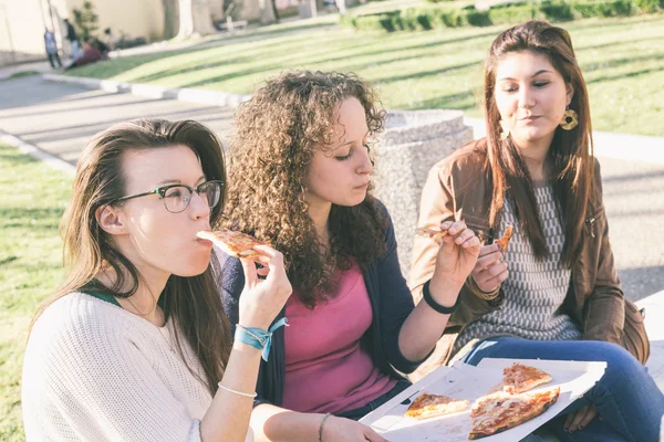 Flickor äta pizza i staden — Stockfoto