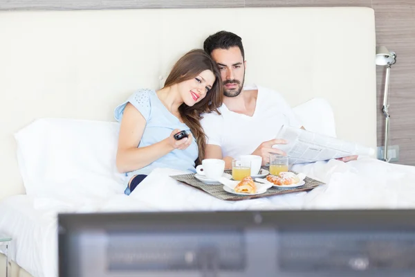 Pareja viendo la televisión en la habitación del hotel — Foto de Stock