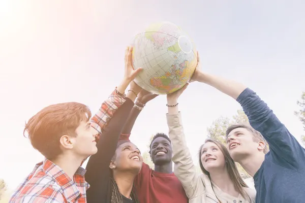 Groep van tieners die houden van de kaart van de wereld van de wereld — Stockfoto